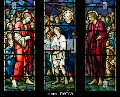 Feeding the Multitude stained glass, St. George`s Church, Ticknall, Derbyshire, England, UK Stock Photo